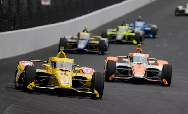 Alex Palou, of Spain, leads a pack of cars during practice for the Indianapolis 500 auto race at the Indianapolis Motor Speedway in Indianapolis, Monday, May 18, 2026. (AP Photo/Michael Conroy)
