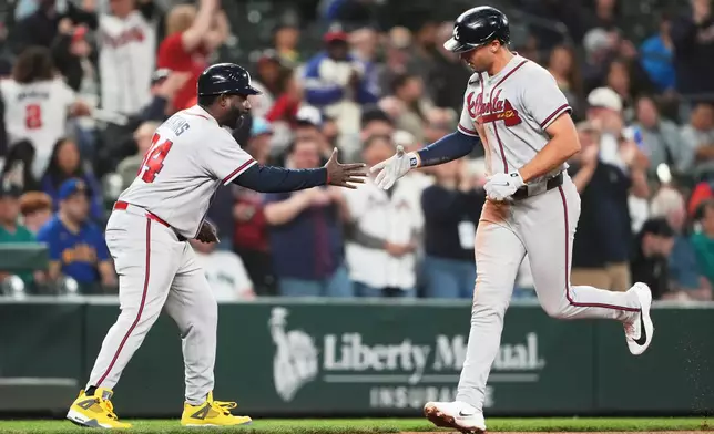 Atlanta Braves' Matt Olson greets third base coach Tommy Watkins while jogging home after hitting a solo home run against the Seattle Mariners during the ninth inning of a baseball game, Tuesday, May 5, 2026, in Seattle. (AP Photo/Lindsey Wasson)