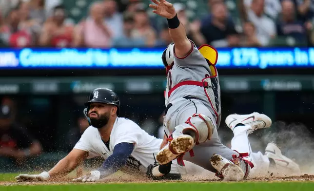 Detroit Tigers' Riley Greene, right, slides safely into home plate ahead of the tag of Cleveland Guardians catcher Austin Hedges, left, during the fourth inning of a baseball game Tuesday, May 19, 2026, in Detroit. (AP Photo/Paul Sancya)