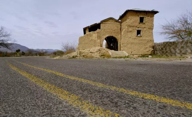 FILE - Texas State Highway 170 passes The Mission del Sagrado Corazon in Ruidosa, Texas, Feb. 9, 2005. The church once had a second tower on the front left like that one on the right. The pile of mud debris from the collapsed tower can still be seen on the front left. (AP Photo/Tony Gutierrez)