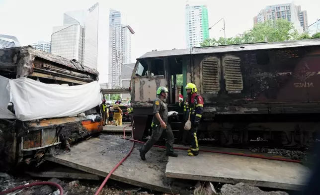 Rescuers work at a train crash site near an airport rail link station in Bangkok, Thailand, Saturday, May 16, 2026. (AP Photo/Sakchai Lalit)