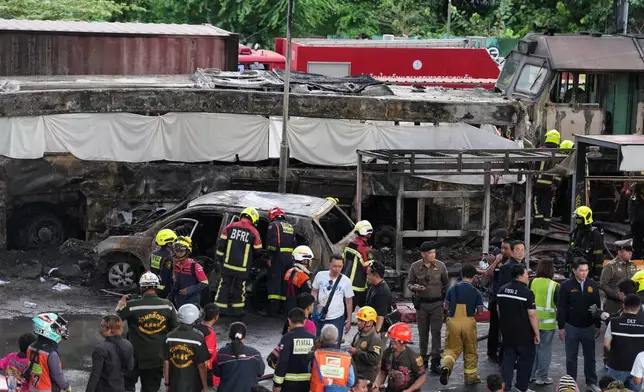 First responders work at a train crash site near an airport rail link station in Bangkok, Thailand, Saturday, May 16, 2026. (AP Photo/Sakchai Lalit)