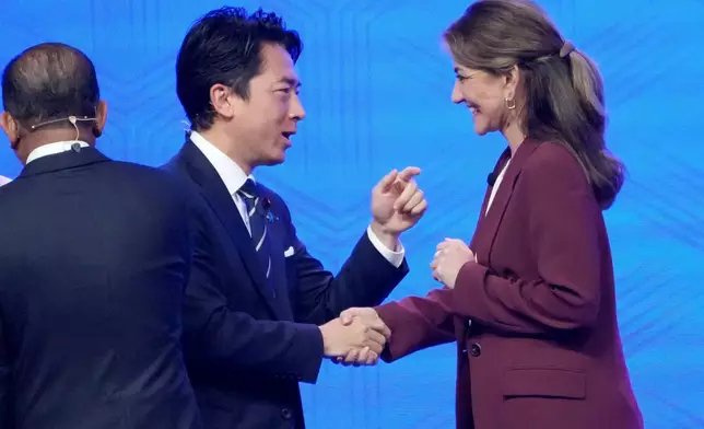 Japan's Defense Minister Shinjiro Koizumi, center, shakes hands with Netherland's Defense Minister Dilan Yesilgoz Zegerius, right, during the Shangri-La Dialogue, Asia's annual defense and security forum, in Singapore, Sunday, May 31, 2026. (AP Photo/Achmad Ibrahim)