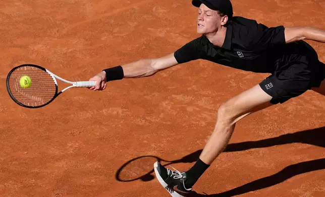 Italy's Jannik Sinner stretches to return the ball to Australia's Alexei Popyrin, during their match at the Italian Open tennis tournament in Rome, Monday, May 11, 2026. (AP Photo/Alessandra Tarantino)