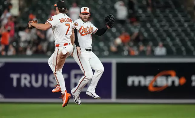 Baltimore Orioles second baseman Jackson Holliday (7) and left fielder Taylor Ward, right, celebrate their team's victory over the Tampa Bay Rays in a baseball game, Tuesday, May 26, 2026, in Baltimore. (AP Photo/Stephanie Scarbrough)