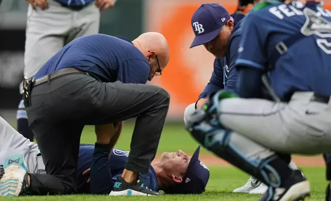 Tampa Bay Rays starting pitcher Griffin Jax is examined by a trainer after an injury during the second inning of a baseball game against the Baltimore Orioles, Tuesday, May 26, 2026, in Baltimore. (AP Photo/Stephanie Scarbrough)