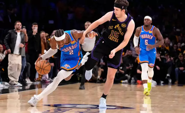 Oklahoma City Thunder guard Shai Gilgeous-Alexander, left, drives by Los Angeles Lakers guard Austin Reaves during the second half of Game 4 in a second-round NBA basketball playoffs series Monday, May 11, 2026, in Los Angeles. (AP Photo/Mark J. Terrill)