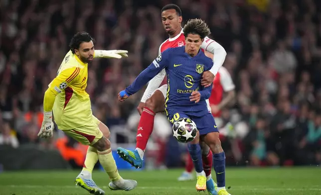 Atletico Madrid's Giuliano Simeone, right, vies for the ball with Arsenal's Gabriel Magalhaes in the box during a Champions League semifinal, second leg, soccer match between Arsenal FC and Atletico Madrid in London, Tuesday, May 5, 2026. (AP Photo/Alastair Grant)
