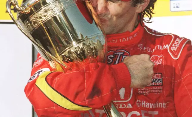 FILE - Italian driver Alex Zanardi kisses the winners trophy at the Australian Indy Car race in Surfers Paradise, Queensland, Sunday, October 18, 1998. (AP Photo/Steve Holland, File)