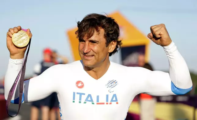 FILE - Alessandro Zanardi of Italy celebrates holding his gold medal following the medal ceremony for the man's road cycle individual time trial H4 category at the 2012 Paralympics games, Wednesday, Sept. 5, 2012, at Brands Hatch motor racing circuit near London. (AP Photo/Alastair Grant, File)