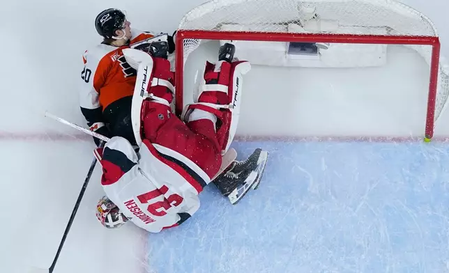 Philadelphia Flyers' Alex Bump, left, collides with Carolina Hurricanes' Frederik Andersen during the second period of Game 3 in the second round of the NHL hockey Stanley Cup playoffs, Thursday, May 7, 2026, in Philadelphia. (AP Photo/Matt Slocum)