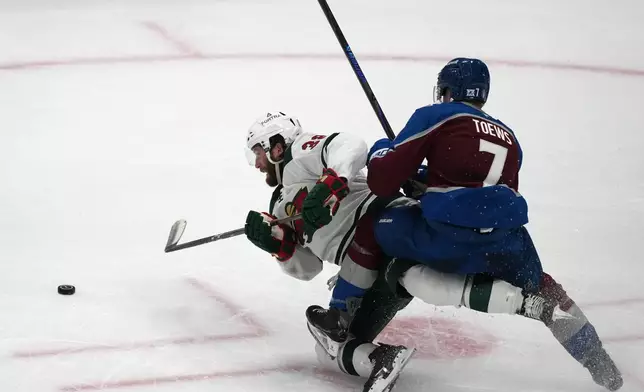 Minnesota Wild right wing Ryan Hartman, left, gets tangled up with Colorado Avalanche defenseman Devon Toews while pursuing the puck in the third period of Game 2 of an NHL hockey Stanley Cup second-round playoff series Tuesday, May 5, 2026, in Denver. (AP Photo/David Zalubowski)