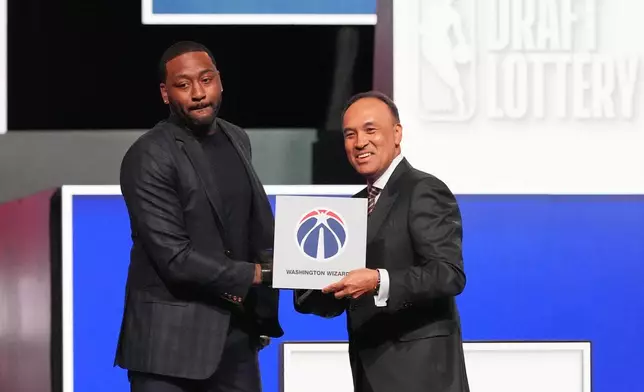 Washington Wizards' John Wall, left, and NBA Deputy Commissioner Mark Tatum, pose for photos after Tatum announced that the Wizards had won the first pick in the NBA basketball draft lottery in Chicago, Sunday, May 10, 2026. (AP Photo/Nam Y. Huh)