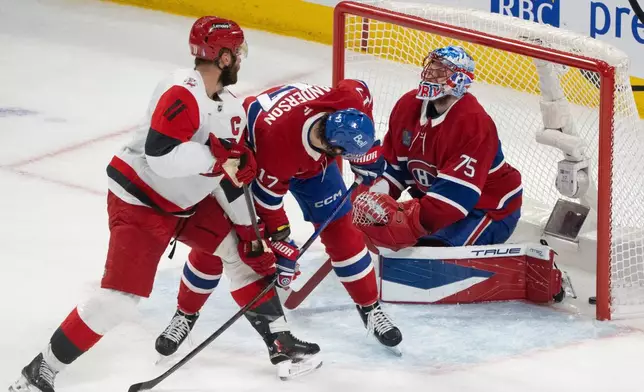 Montreal Canadiens goaltender Jakub Dobes (75) reacts as he is scored on by Carolina Hurricanes' Jordan Staal (11) as Canadiens' Josh Anderson (17) defends during the first period of Game 4 of NHL Eastern Conference final Stanley Cup playoff series action in Montreal, Quebec, Wednesday, May 27, 2026. (Christinne Muschi/The Canadian Press via AP)