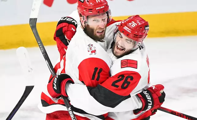 Carolina Hurricanes' Jordan Staal (11) celebrates with teammate Sean Walker (26) after scoring against the Montreal Canadiens during the first period of Game 4 of NHL Eastern Conference final Stanley Cup playoff series action in Montreal, Quebec, Wednesday, May 27, 2026. (Graham Hughes/The Canadian Press via AP)