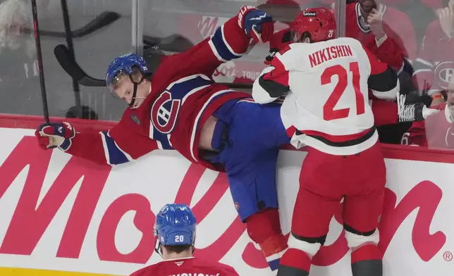 Carolina Hurricanes' Alexander Nikishin (21) checks Montreal Canadiens' Kaiden Guhle during the second period of Game 4 of NHL Eastern Conference final Stanley Cup playoff series game in Montreal on Wednesday, May 27, 2026. (Christinne Muschi/The Canadian Press via AP)