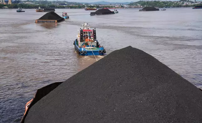 FILE - Tug boats pull barges fully loaded with coal on the Mahakam river in Samarinda, East Kalimantan, Indonesia, on Dec. 19, 2022. (AP Photo/Dita Alangkara, File)