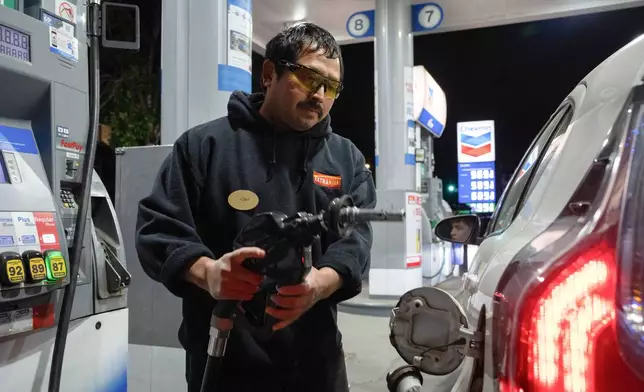 An attendant prepares to fill a customers tank at a gas station on Wednesday, May 6, 2026, in Portland, Ore. (AP Photo/Jenny Kane)
