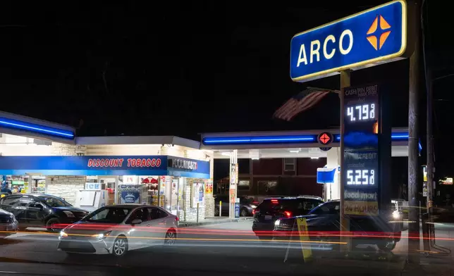 In this image taken with a slow shutter speed, vehicles move past a gas station on Wednesday, May 6, 2026, in Portland, Ore. (AP Photo/Jenny Kane)