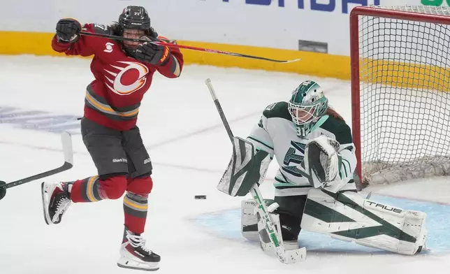 Ottawa Charge's Fanuza Kadirova, left, jumps to screen Boston Fleet goalie Aerin Frankel, right, during third-period PWHL hockey playoff action in Ottawa, Ontario, Friday, May 8, 2026. (Adrian Wyld/The Canadian Press via AP)