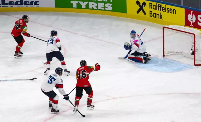 Hungary's Istvan Terbocs, left, scores during the Men's Ice Hockey World Championship preliminary round game between Hungary and Great Britain, in Zurich, Switzerland, Tuesday May 19, 2026. (Andreas Becker/Keystone via AP)