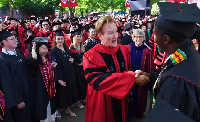 Comedian Conan O'Brien, center, greets people while walking in a procession through Harvard Yard, before delivering a commencement address during Harvard University commencement exercises on the school's campus, Thursday, May 28, 2026, in Cambridge, Mass. (AP Photo/Steven Senne)
