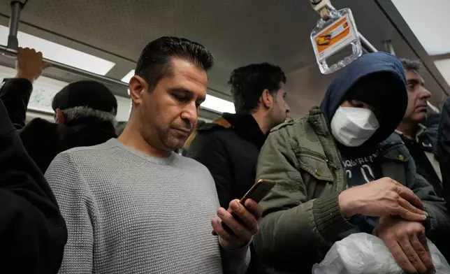 FILE - A man uses his smartphone while riding the subway in Tehran, Iran, Tuesday, Dec. 24, 2024. (AP Photo/Vahid Salemi, File)