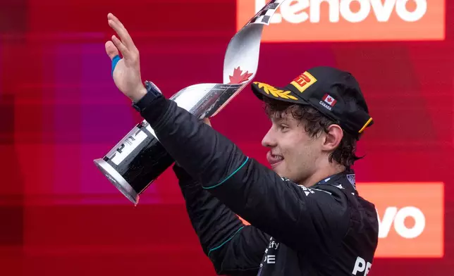 Mercedes driver Kimi Antonelli, of Italy, waves as he holds his trophy following his win in the F1 Canadian Grand Prix auto race in Montreal, Sunday, May 24, 2026. (Christinne Muschi/The Canadian Press via AP)