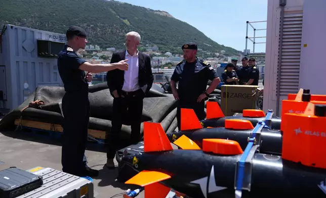 Britain's Armed Forces Minister Al Carns, centre, inspects autonomous vehicles with sonar sensor that can detect and identify mines, on RFA Lyme Bay in territory of Gibraltar, on Friday, May 22, 2026. (AP Photo/Kwiyeon Ha)