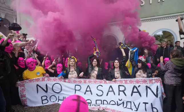 EDS NOTE: NUDITY - Pussy Riot and FEMEN activists stage a protest against Russia's presence after its absence following the 2022 invasion of Ukraine in front of the Russian pavilion, at the 2026 Art Venice Biennale, in Venice, Italy, Wednesday, May 6, 2026. Writing on banner partially reads in Ukrainian "God... will pass"(AP Photo/Luca Bruno)