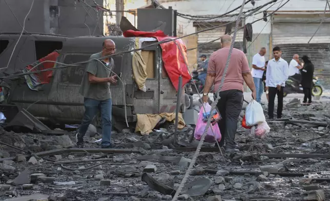 A man carries his belongings, as he leaves the site of destroyed buildings that were hit in Israeli airstrikes in the southern port city of Tyre, Lebanon, Thursday, May 28, 2026. (AP Photo)