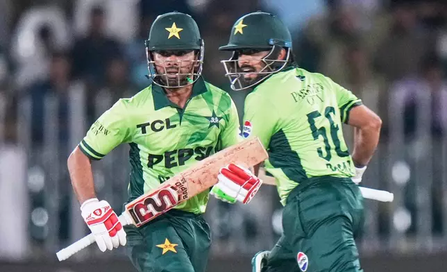 Pakistan's Ghazi Ghori, left, and Babar Azam run between the wickets to score during the first one day international cricket match between Pakistan and Australia, in Rawalpindi, Pakistan, Saturday, May 30, 2026. (AP Photo/Anjum Naveed)