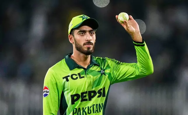Pakistan's Arafat Minhas, who took five wickets, displays the ball as he walks off the field on the end of first innings during the first one day international cricket match between Pakistan and Australia, in Rawalpindi, Pakistan, Saturday, May 30, 2026. (AP Photo/Anjum Naveed)