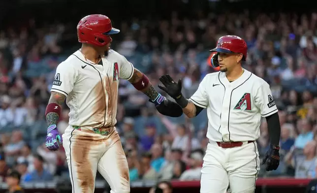 Arizona Diamondbacks' Ketel Marte, left, celebrates his run scored against the Pittsburgh Pirates with Diamondbacks' Ildemaro Vargas during the first inning of a baseball game, Tuesday, May 5, 2026, in Phoenix. (AP Photo/Ross D. Franklin)