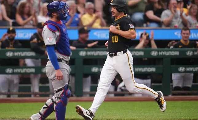 Pittsburgh Pirates' Bryan Reynolds (10) score behind Chicago Cubs catcher Carson Kelly on a single by Oneil Cruz off Cubs pitcher Jordan Wicks during the first inning of a baseball game in Pittsburgh, Tuesday, May 26, 2026. (AP Photo/Gene J. Puskar)