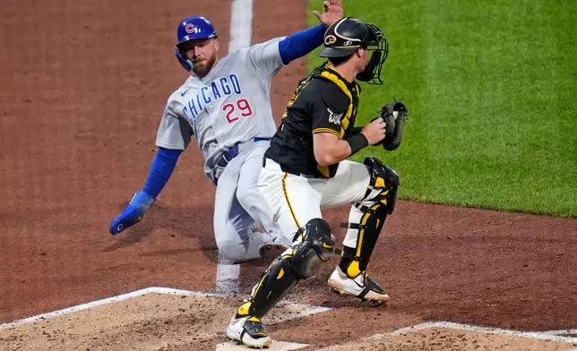 Pittsburgh Pirates catcher Henry Davis, right, gets the force out at home plate on Chicago Cubs' Michael Busch (29) who was forced from third on a fielder's choice by Cubs' Moisés Ballesteros during the sixth inning of a baseball game in Pittsburgh, Tuesday, May 26, 2026. (AP Photo/Gene J. Puskar)