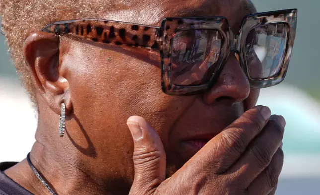 Underwater Adventure Seekers member Ruthie Browning reacts with emotion after pouring a libation of white rum onto the sand, on the site where hundreds of Africans who died in 1860 after being rescued from three slave ships were buried, on Higgs Beach in Key West, Fla., Saturday, May 9, 2026. (AP Photo/Rebecca Blackwell)