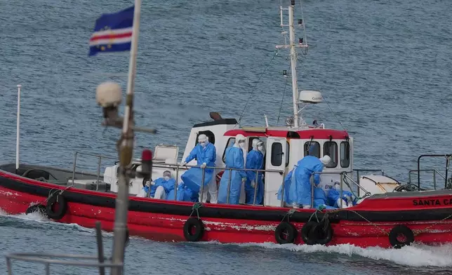 Health workers in protective gear arrive to evacuate patients from the MV Hondius cruise ship at a port in Praia, Cape Verde, Wednesday, May 6, 2026. (AP Photo/Misper Apawu)