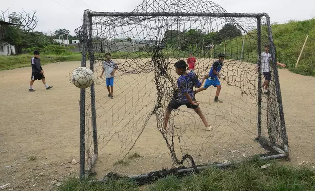 Youth play soccer on a dirt soccer field in the Cooperativa San Francisco neighborhood of Guayaquil, Ecuador, Friday, May 15, 2026. (AP Photo/Dolores Ochoa)