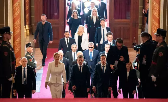 Hungarian Prime Minister-elect Peter Magyar, center, arrives with fellow lawmakers at the Parliament building in Budapest, Hungary, Saturday, May 9, 2026. (AP Photo/Denes Erdos)