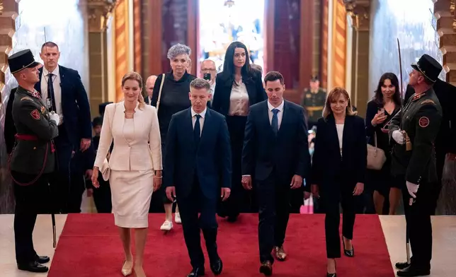 Hungarian Prime Minister-elect Peter Magyar, center, arrives with fellow lawmakers at the Parliament building in Budapest, Hungary, Saturday, May 9, 2026. (AP Photo/Denes Erdos)