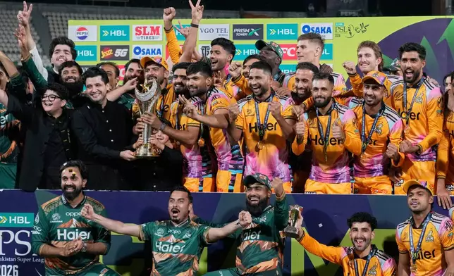 Officials and players of Peshawar Zalmi celebrates as they pose for photo with trophy after winning the Pakistan Super League final cricket match against Hyderabad Kingsmen, in Lahore, Pakistan, Monday, May 4, 2026. (AP Photo/K.M. Chaudary)