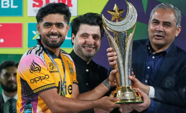 Peshawar Zalmi's skipper Babar Azam, left, receives winning trophy from Pakistan's Interior Minister and Chairman of Pakistan Cricket Board Mohsin Naqvi on the of the Pakistan Super League final cricket match against Hyderabad Kingsmen, in Lahore, Pakistan, Monday, May 4, 2026. (AP Photo/K.M. Chaudary)