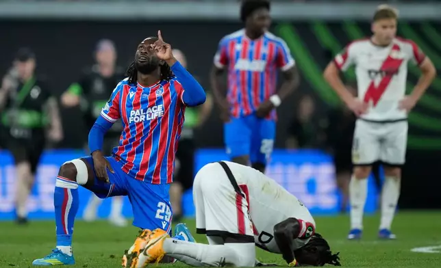 Crystal Palace's Evann Guessanda celebrate next to Rayo's Pathe Ciss after the Europa Conference League final soccer match between Crystal Palace and Rayo Vallecano in Leipzig, Germany, Wednesday, May 27, 2026. (AP Photo/Ebrahim Noroozi)