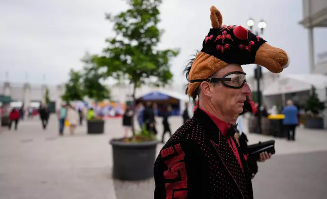 A race fan arrives before the 152nd running of the Kentucky Derby horse race at Churchill Downs, Saturday, May 2, 2026, in Louisville, Ky. (AP Photo/George Walker IV)