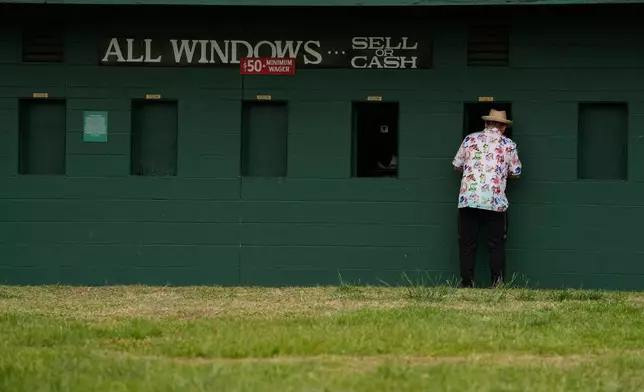 A fan places a bet before the 152nd running of the Kentucky Derby horse race at Churchill Downs, Saturday, May 2, 2026, in Louisville, Ky. (AP Photo/Charlie Riedel)