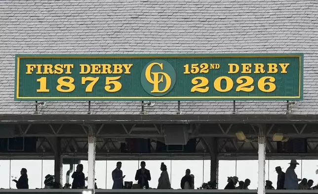 Fans stand under cover before the 152nd running of the Kentucky Derby horse race at Churchill Downs, Saturday, May 2, 2026, in Louisville, Ky. (AP Photo/Charlie Riedel)