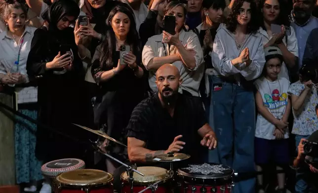 Musician Sadegh Hosseinpour plays percussion during a performance dubbed "Sounds of the South," featuring music from southern Iran, as people watch and film with their smartphones at the Tehran Museum of Contemporary Art in Tehran, Iran, Thursday, May 21, 2026. (AP Photo/Vahid Salemi)
