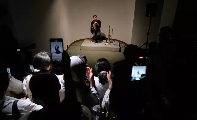 A musician performs as people film with their smartphones during a performance dubbed "Sounds of the South," featuring music from southern Iran, at the Tehran Museum of Contemporary Art in Tehran, Iran, Thursday, May 21, 2026. (AP Photo/Vahid Salemi)