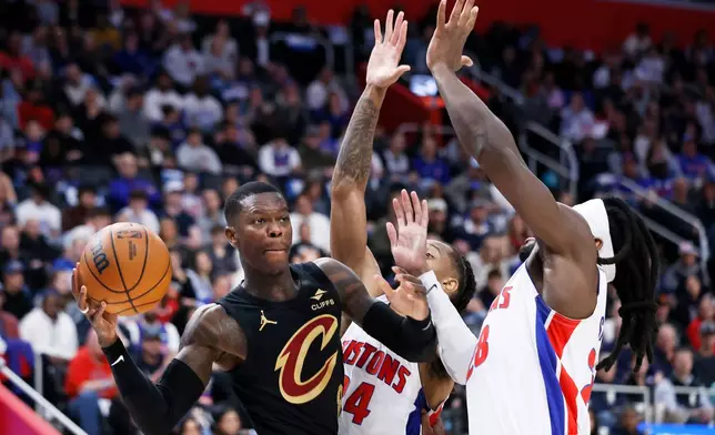 Cleveland Cavaliers guard Dennis Schroder, left, passes the ball against Detroit Pistons guard Daniss Jenkins (24) and forward Isaiah Stewart (28) during the first half in Game 2 of a second-round NBA playoffs basketball series, Thursday, May 7, 2026, in Detroit. (AP Photo/Duane Burleson)
